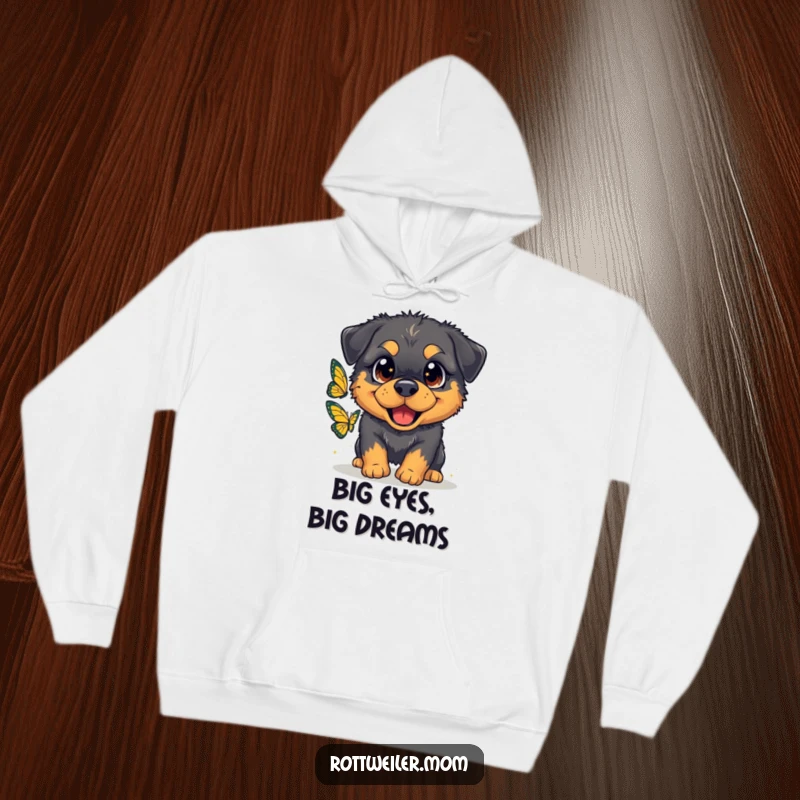 Funny hoodie featuring a fluffy Rottweiler with oversized, sparkling eyes, joyfully chasing a butterfly, perfect for cozy moments.