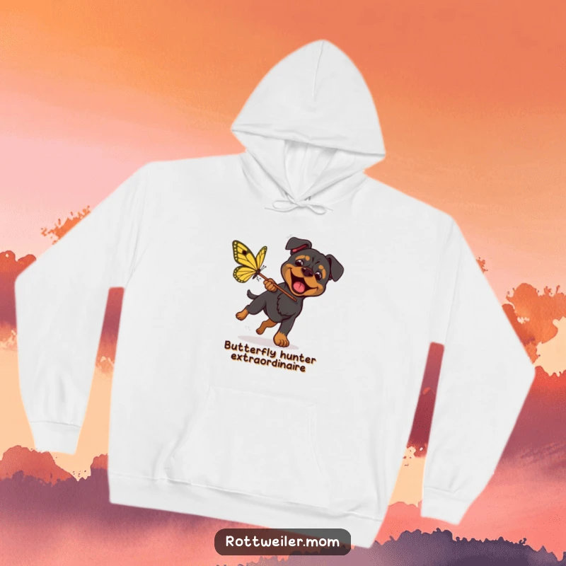 Funny Rottweiler Butterfly Chase Hoodie shows an energetic dog with a net, enthusiastically chasing a gigantic butterfly, full of fun.