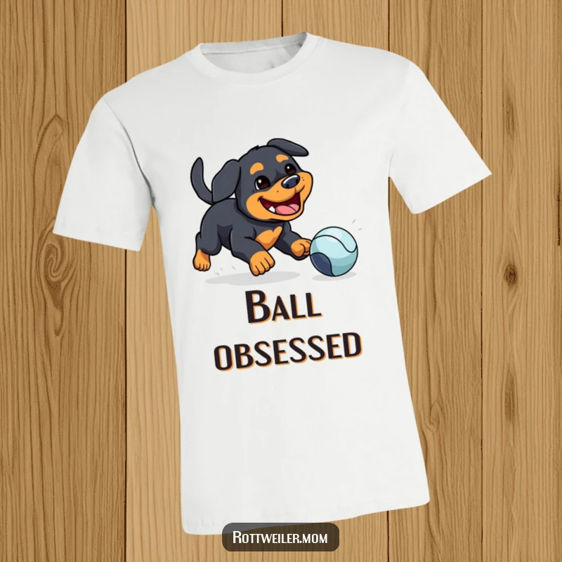 Funny t-shirt: a kawaii Rottweiler with a silly grin joyfully chasing a bouncing ball, celebrating playful dog energy.