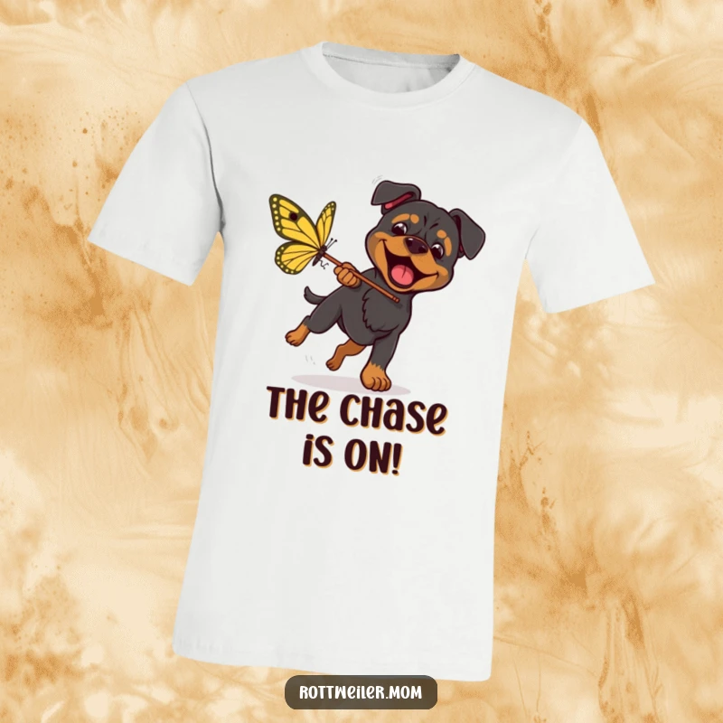 Funny Rottweiler Butterfly Hunt T-Shirt shows an excited dog with a net, chasing a giant butterfly with determination and humor.