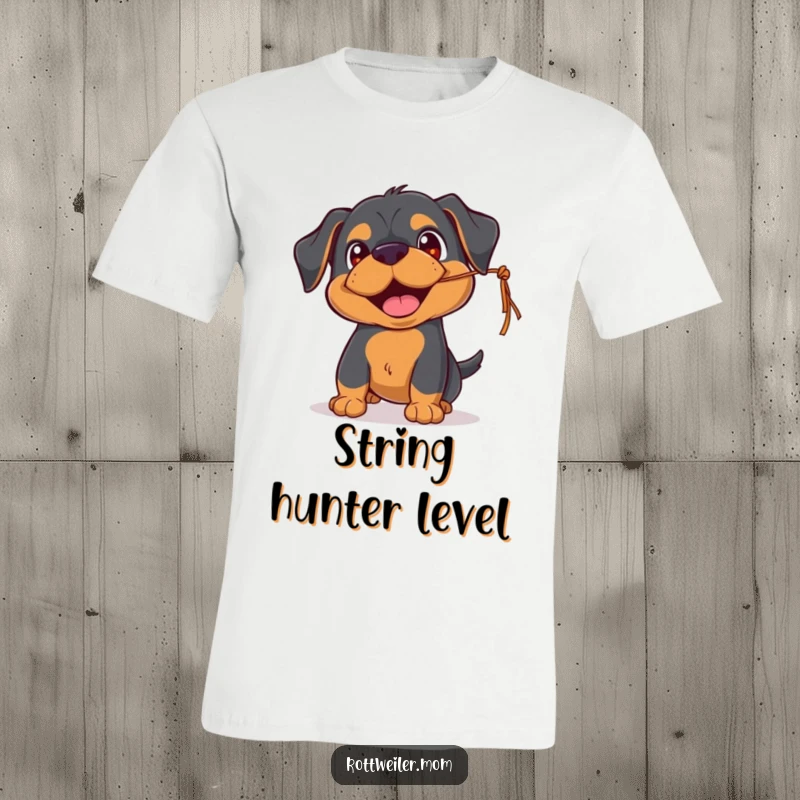 Funny Rottweiler t-shirt showing an excited pup with happy eyes, playfully batting at a dangling string, capturing innocent fun.