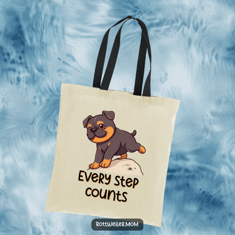 Funny Kawaii Rottweiler Tote Bag with a cute dog climbing a small hill, perfect for carrying everyday items humorously.